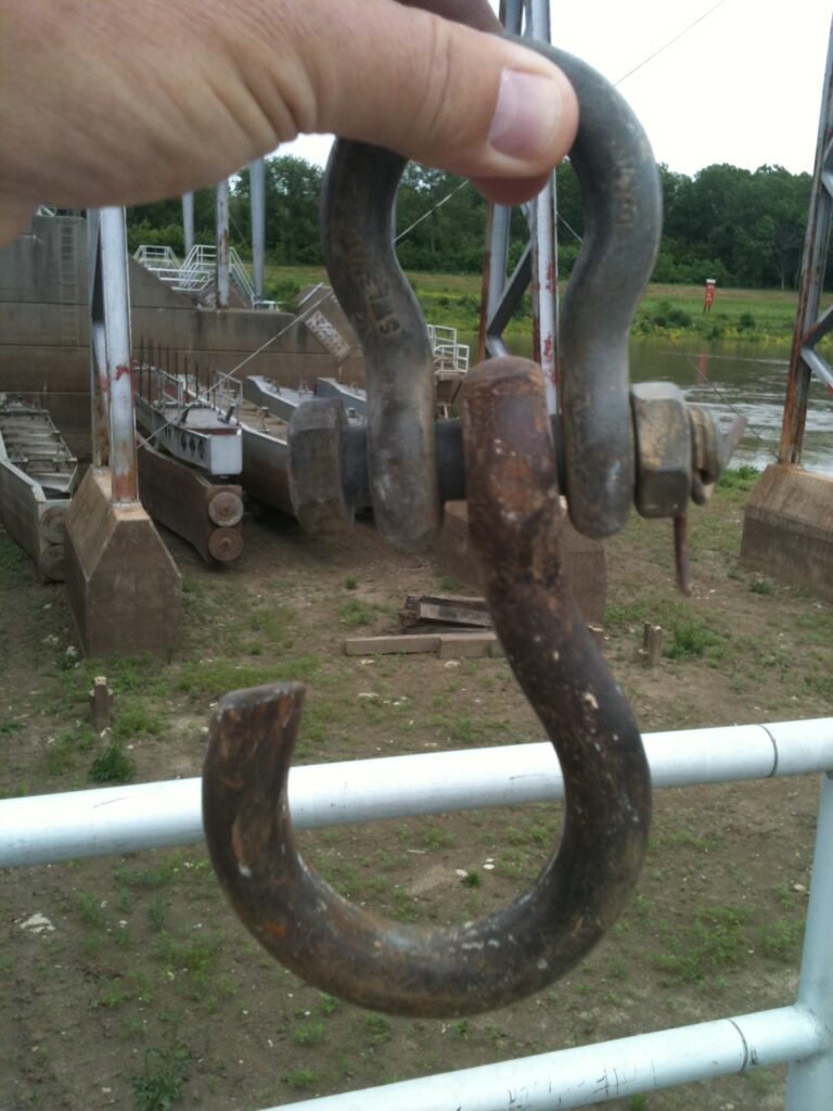 A hand holds a shop made shackle turned into a hook